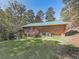 Backyard view shows lush grass and stairs leading to deck of the log cabin style home at 1166 Upper Sweetwater Se Trl, White, GA 30184