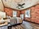 Charming bedroom with a queen bed, wood-paneled walls, and natural light, offering a cozy retreat at 1166 Upper Sweetwater Se Trl, White, GA 30184