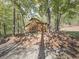 Wood outbuilding with black X detail nestled in a wooded area on a sunny day at 1166 Upper Sweetwater Se Trl, White, GA 30184