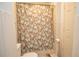 Bathroom includes shower with a floral shower curtain and a toilet with tile floors at 1250 Parkwood Cir # 2312, Atlanta, GA 30339