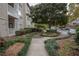 Sidewalk with landscaping leading to condo buildings, parking, and a large shade tree at 1250 Parkwood Cir # 2312, Atlanta, GA 30339