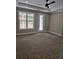 Spacious carpeted bedroom with tray ceilings, white trim, and a large window at 1632 Oleander Sw Dr, Lilburn, GA 30047