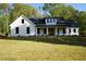 Beautiful white farmhouse with black trim, covered porch, and a large front yard at 1632 Oleander Sw Dr, Lilburn, GA 30047