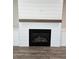 Close up of a modern fireplace with shiplap and a wooden mantle at 1632 Oleander Sw Dr, Lilburn, GA 30047
