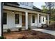 Inviting front porch with stone flooring, white columns, and modern lighting fixtures at 1632 Oleander Sw Dr, Lilburn, GA 30047