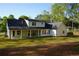 Exterior rear view of home showcasing a covered patio and sprawling backyard at 1632 Oleander Sw Dr, Lilburn, GA 30047