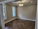 A simple room with hardwood flooring, a modern light fixture, and bright windows at 1632 Oleander Sw Dr, Lilburn, GA 30047