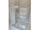Walk-in shower enclosed in glass, accented by marbled tile and a matching tile floor at 1632 Oleander Sw Dr, Lilburn, GA 30047