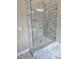 Walk-in shower enclosed in glass, accented by marbled tile and a matching tile floor at 1632 Oleander Sw Dr, Lilburn, GA 30047