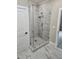 Modern tiled shower with glass door and marble-look accent tiles, creating a luxurious spa-like experience at 1632 Oleander Sw Dr, Lilburn, GA 30047