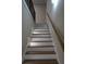 Wooden staircase with white risers is illuminated by recessed stair lights, providing a warm ambiance at 1632 Oleander Sw Dr, Lilburn, GA 30047