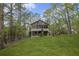 Green backyard with a home featuring many windows surrounded by trees in the background at 1670 Nordic Trce, Marietta, GA 30068