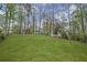 Lush green backyard featuring green grass and trees in the background at 1670 Nordic Trce, Marietta, GA 30068