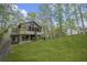 Green backyard featuring home in the background with large windows surrounded by trees at 1670 Nordic Trce, Marietta, GA 30068