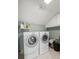 A laundry room featuring a side by side washer and dryer, tile flooring, and storage shelves at 1670 Nordic Trce, Marietta, GA 30068