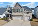 Inviting home featuring a stone facade, a two-car garage, and manicured landscaping at 127 Crest Brooke Dr, Canton, GA 30115