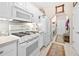 Galley kitchen with a white range hood, gas stove, and adjacent laundry area at 1478 Settlers Walk Sw Way, Marietta, GA 30060