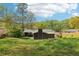 Large backyard with trees, grass, and house view with a chimney at 2407 Ridgeway Dr, Doraville, GA 30360