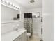 Bright bathroom features a large mirror, updated vanity, and shower with decorative curtain at 2407 Ridgeway Dr, Doraville, GA 30360