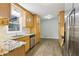 Well-lit kitchen featuring wooden cabinets, granite countertops, and stainless steel appliances at 2407 Ridgeway Dr, Doraville, GA 30360