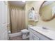 Standard bathroom with a single sink, round mirror, and shower-tub combo with a neutral-toned curtain at 250 Blackberry Ln, Douglasville, GA 30134