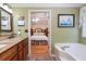 Bathroom features a soaking tub, granite countertop vanity, and doorway to the primary bedroom at 250 Blackberry Ln, Douglasville, GA 30134
