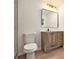 Bathroom with rustic wood vanity, square mirror, modern light fixture, and white toilet at 2901 Lenox Ne Rd # 901, Atlanta, GA 30324