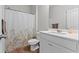 Bathroom featuring a shower with decorative shower curtain, white vanity, and wood look flooring at 133 Bastian Rd, Mcdonough, GA 30252