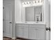 Stylish bathroom featuring double sinks, a large mirror, white cabinets and modern fixtures at 133 Bastian Rd, Mcdonough, GA 30252