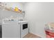 Efficient laundry room with white appliances and a shelf for organized storage solutions at 133 Bastian Rd, Mcdonough, GA 30252