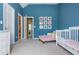 Blue bedroom with light-colored carpet and trim, featuring a crib and seating at 2296 Valley Brook Ne Way, Atlanta, GA 30319