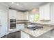 Spacious kitchen with granite countertops, gas cooktop island, stainless steel appliances, and white cabinetry at 2296 Valley Brook Ne Way, Atlanta, GA 30319