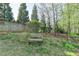 Serene backyard setting with a wooden bench amidst the trees and greenery at 4230 Braden Nw Ln, Kennesaw, GA 30144