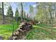 Picturesque backyard with stacked firewood, a cozy seating area, and a lush green lawn at 4230 Braden Nw Ln, Kennesaw, GA 30144