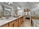 Bright bathroom with double vanity, soaking tub, walk-in shower, and view into the main bedroom at 4230 Braden Nw Ln, Kennesaw, GA 30144