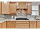 Gas range and white countertop over stylish stone backsplash and wood cabinets in well appointed kitchen at 4230 Braden Nw Ln, Kennesaw, GA 30144