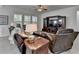 Bright living room featuring tile flooring, comfortable seating, and a dark wood entertainment center at 4230 Braden Nw Ln, Kennesaw, GA 30144