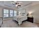 Primary bedroom suite featuring a tray ceiling, ceiling fan, and large windows at 4230 Braden Nw Ln, Kennesaw, GA 30144