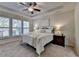 Primary bedroom suite featuring a tray ceiling, ceiling fan, and large windows at 4230 Braden Nw Ln, Kennesaw, GA 30144