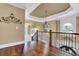 Upstairs landing with wood floors, chandelier, and railing overlooking the foyer at 2450 Weber Heights Way, Buford, GA 30519