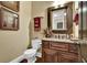 Well-appointed powder room with granite countertops, framed mirrors, and wood cabinetry at 2450 Weber Heights Way, Buford, GA 30519