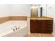 A well-lit bathroom features a soaking tub, granite-topped vanity with wood cabinets, and a walk-in shower at 264 19Th Nw St # 2308, Atlanta, GA 30363