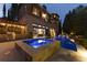 Backyard at dusk with an illuminated pool, hot tub, string lights, and a well-manicured lawn at 290 Ardsley Ln, Alpharetta, GA 30005