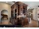 Custom-built wet bar with intricate woodwork, glass shelves, and ample storage, perfect for entertaining guests in style at 290 Ardsley Ln, Alpharetta, GA 30005