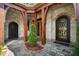 Elegant courtyard with stone floors, wooden beams, and two wrought-iron front doors at 290 Ardsley Ln, Alpharetta, GA 30005