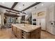 Open kitchen with an island, stone floors, wooden beams and cabinetry, and stainless-steel appliances at 290 Ardsley Ln, Alpharetta, GA 30005