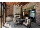 Elegant outdoor patio featuring a stone fireplace, grill, and comfortable seating, seamlessly blending indoor and outdoor living spaces at 290 Ardsley Ln, Alpharetta, GA 30005