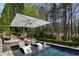 Inviting pool area featuring luxurious chaise lounges and a large shade umbrella for ultimate relaxation at 290 Ardsley Ln, Alpharetta, GA 30005