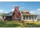View of the rear exterior, brick chimney and sunroom of this 2 story home on a sunny day at 3560 Glen Summit Ln, Snellville, GA 30039