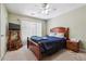 Comfortable bedroom with a wooden bed frame, ceiling fan, and window with blinds at 3560 Glen Summit Ln, Snellville, GA 30039